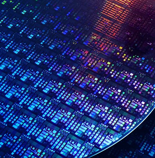 Nahaufnahme einer Halbleiterwafer-Oberfläche mit vielen rechteckigen und quadratischen Strukturen in verschiedenen Farben