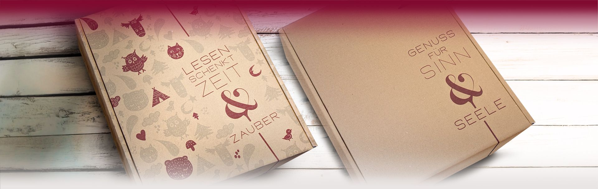 Zwei Pappverpackungen mit Schriftzügen 'LESEN SCHENKT ZEIT & ZAUBER' und 'GENUSS FÜR SINN & SEELE' auf hellem Holzhintergrund - DART