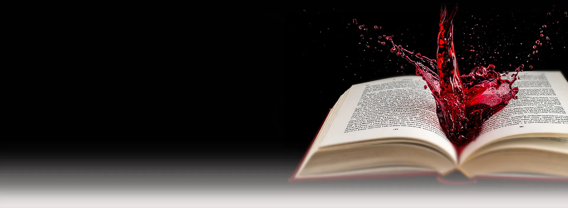 Offenes Buch mit spritzendem rotem Wein auf schwarzem Hintergrund - DART